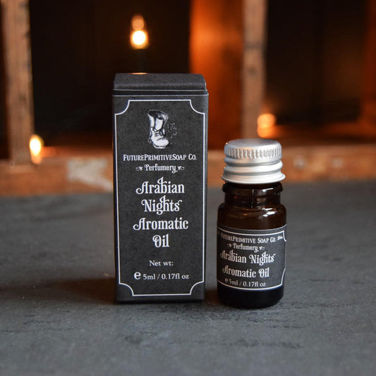 Aromatic oil bottle and packaging with 'Arabian Nights' label against a warm-toned background.