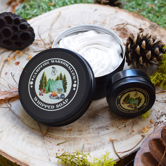 Campfire Marshmallow Whipped Soap in a black container on a wooden surface with nature-themed design.