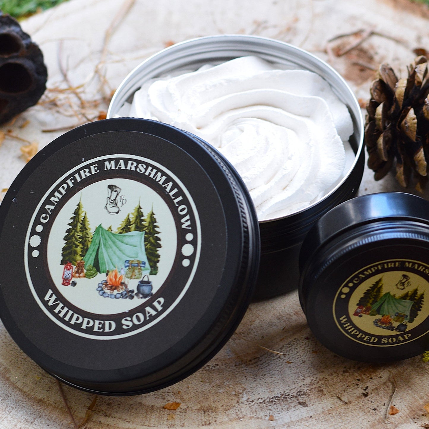 Campfire Marshmallow Whipped Soap in a black container on a wooden surface with nature-themed design.