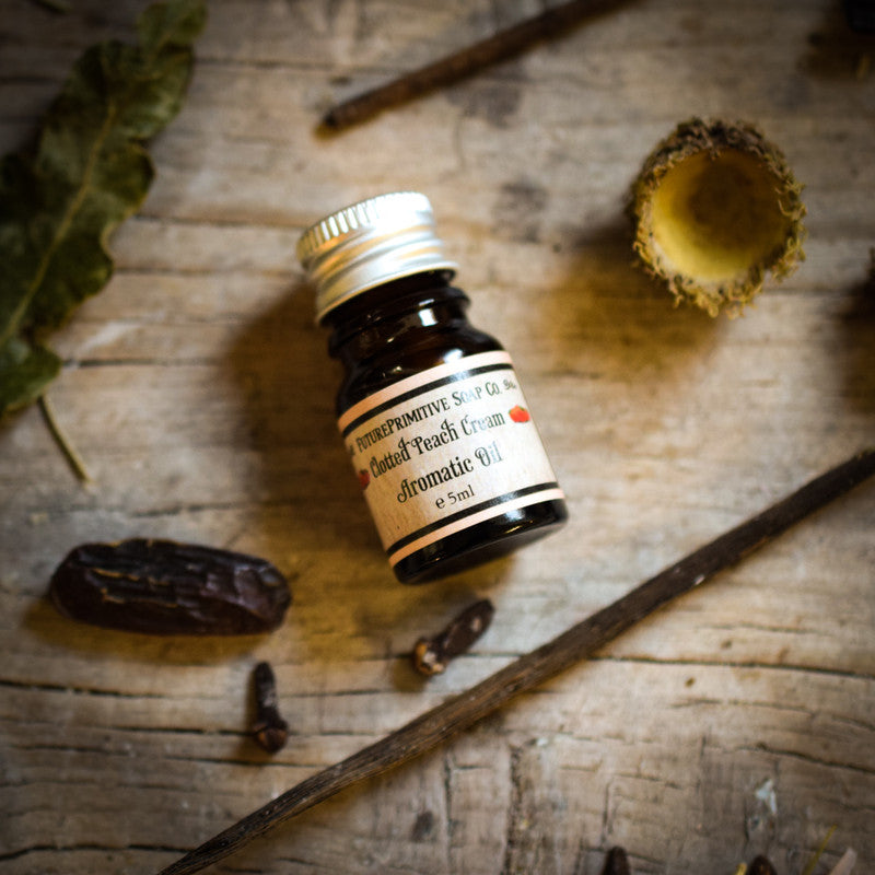 Small bottle of peach perfume on a wooden surface with natural elements