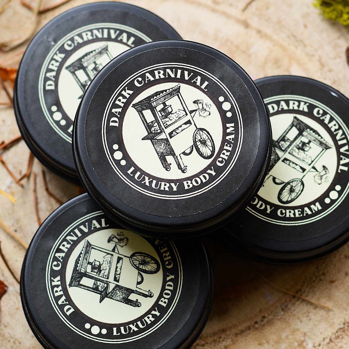 Dark Carnival mini body creams on a natural background with pine cones and moss
