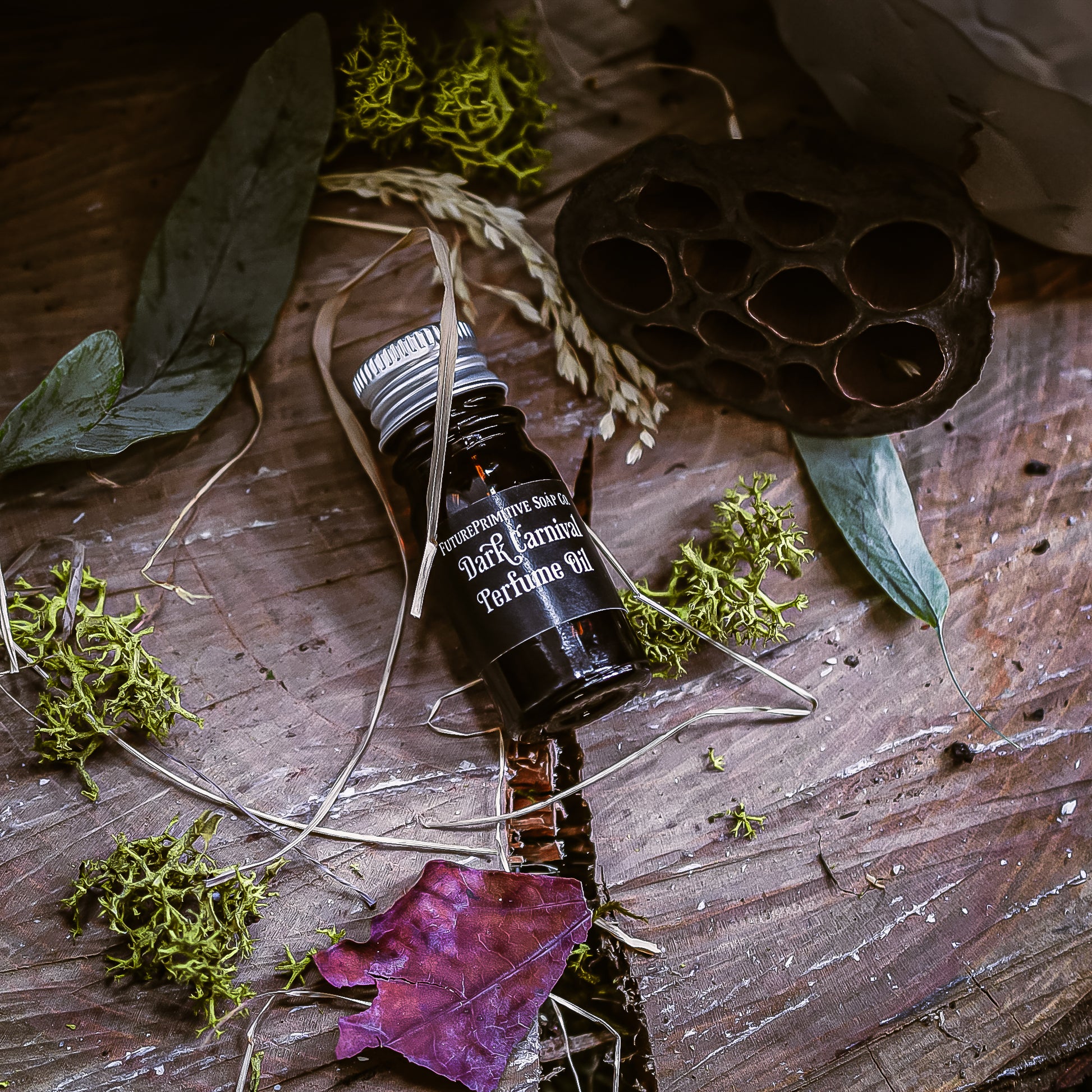 Bottle of Dark Cornich perfume oil on a wooden surface with leaves and natural elements