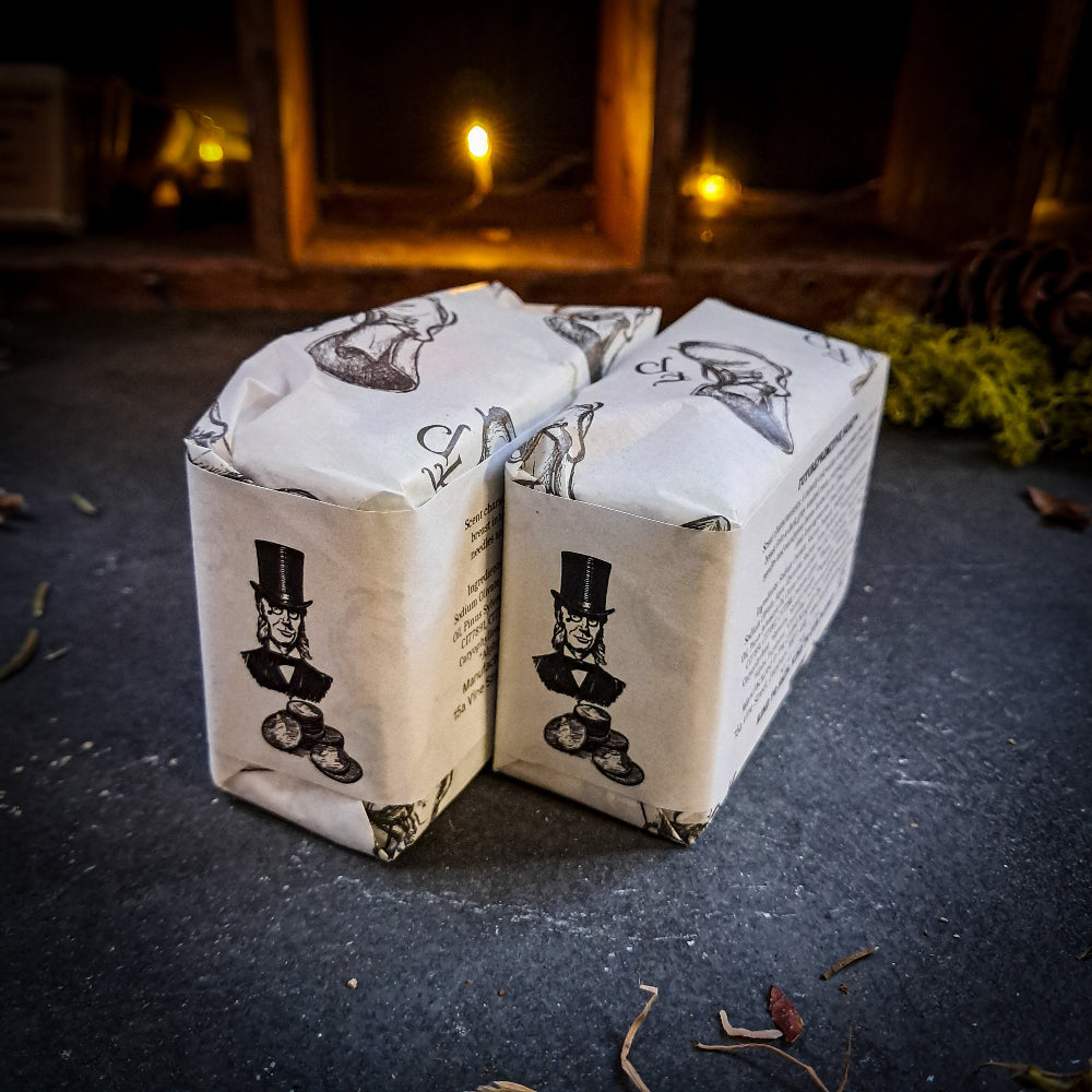 Three stacked boxes with a top hat design on a dark surface