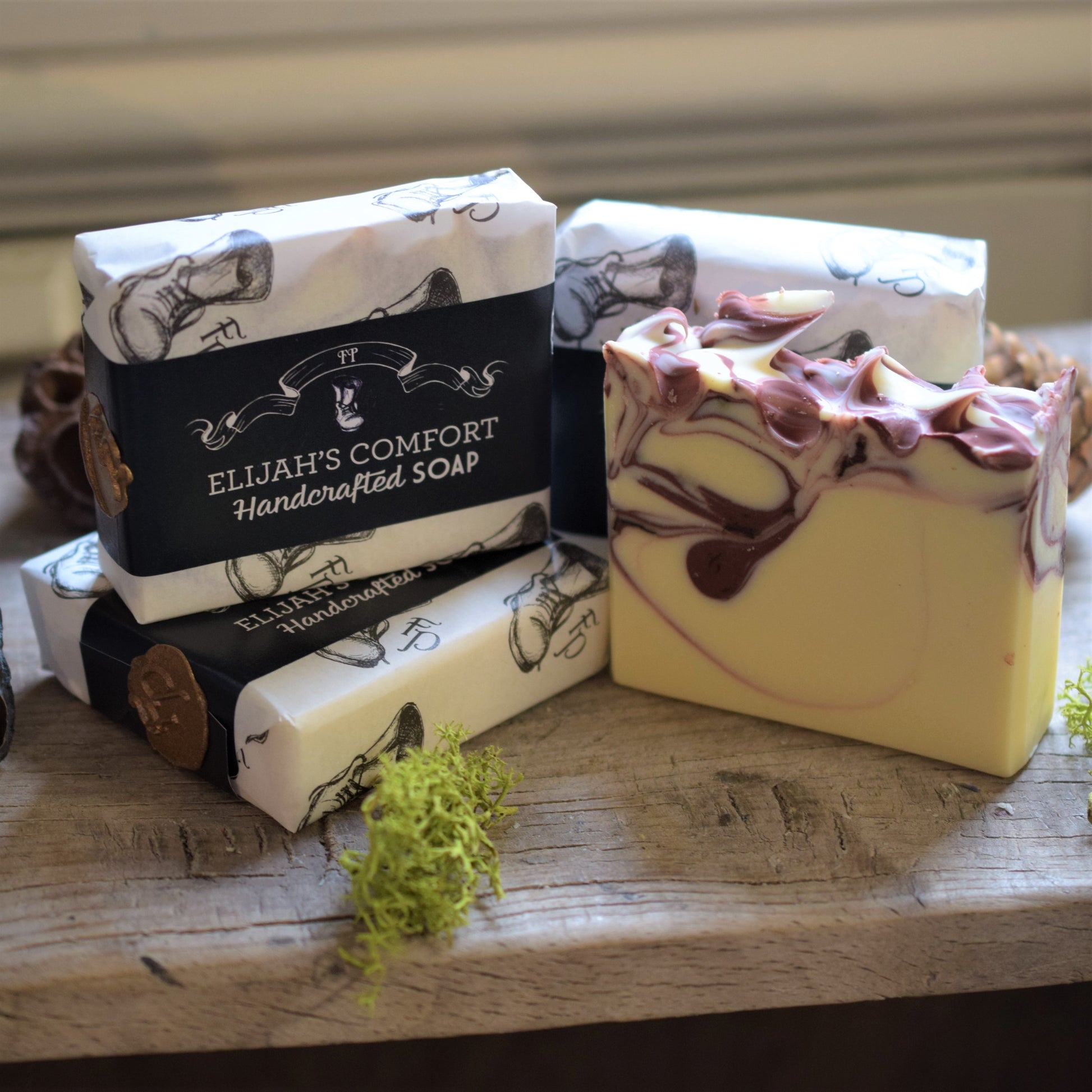 Handcrafted soap bars with visible brand name on a wooden surface