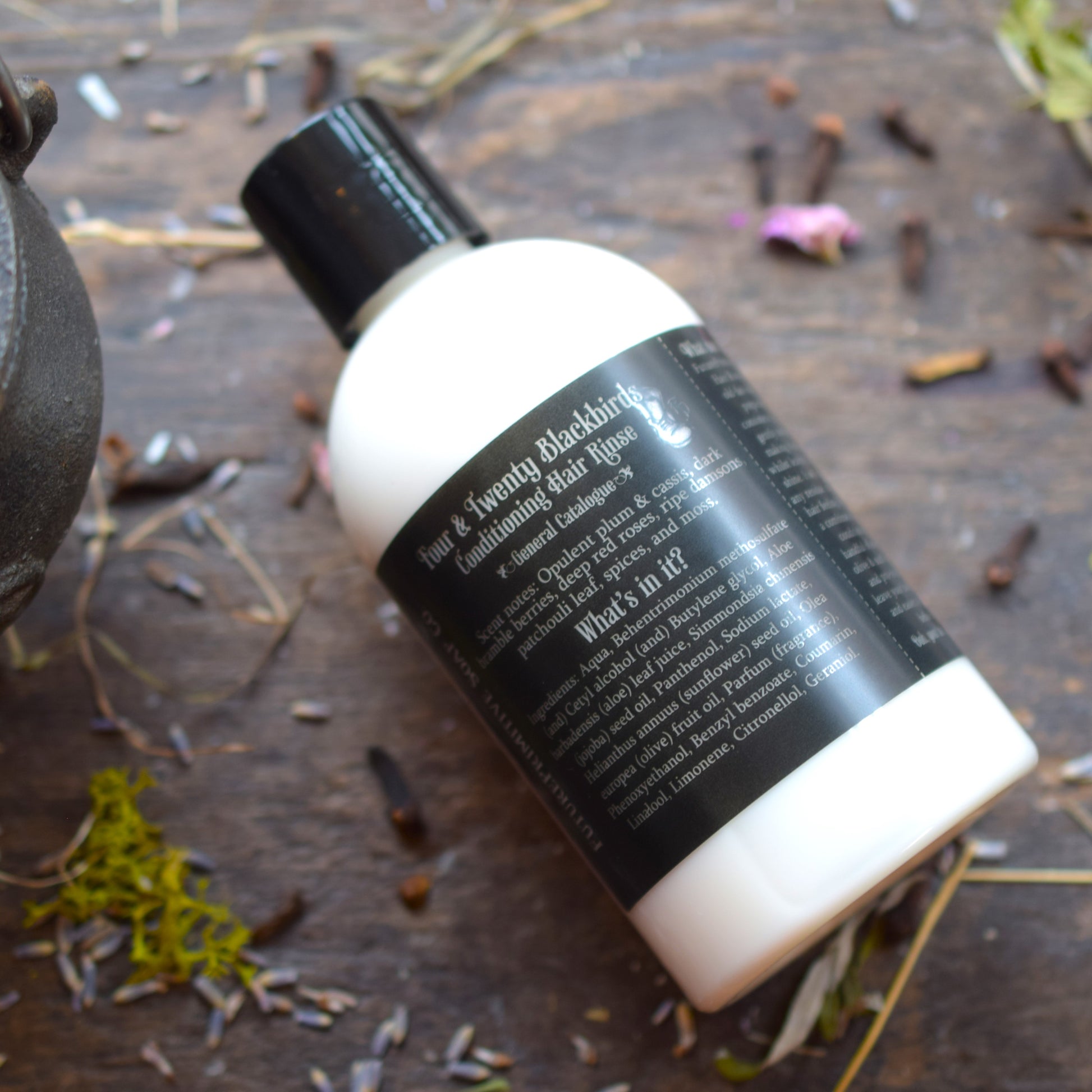 Bottle of hair product on a wooden surface with natural elements