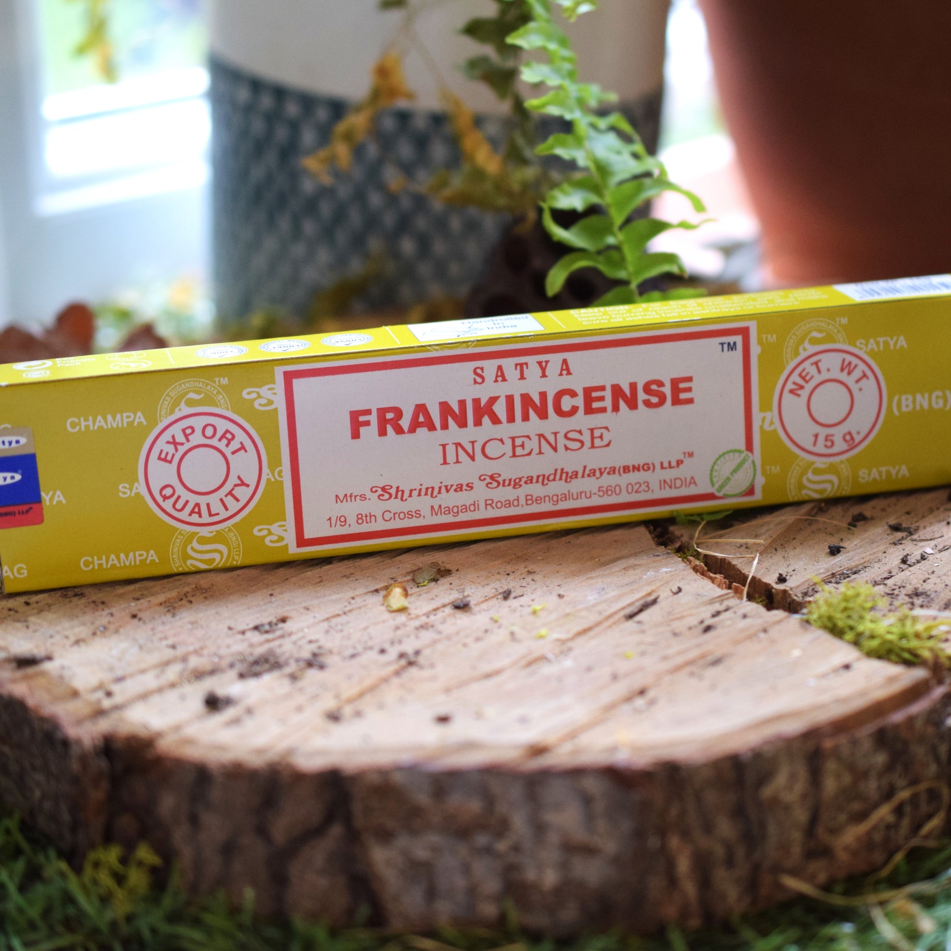 Box of Satya Frankincense Incense on a wooden surface with plants in the background