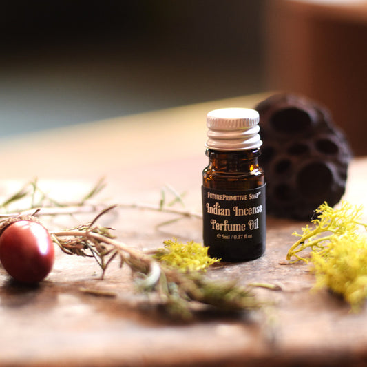Bottle of Indian Incense Perfume Oil on a wooden surface with natural elements