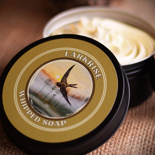 Larkrise whipped soap in a black container with a decorative label featuring a bird.