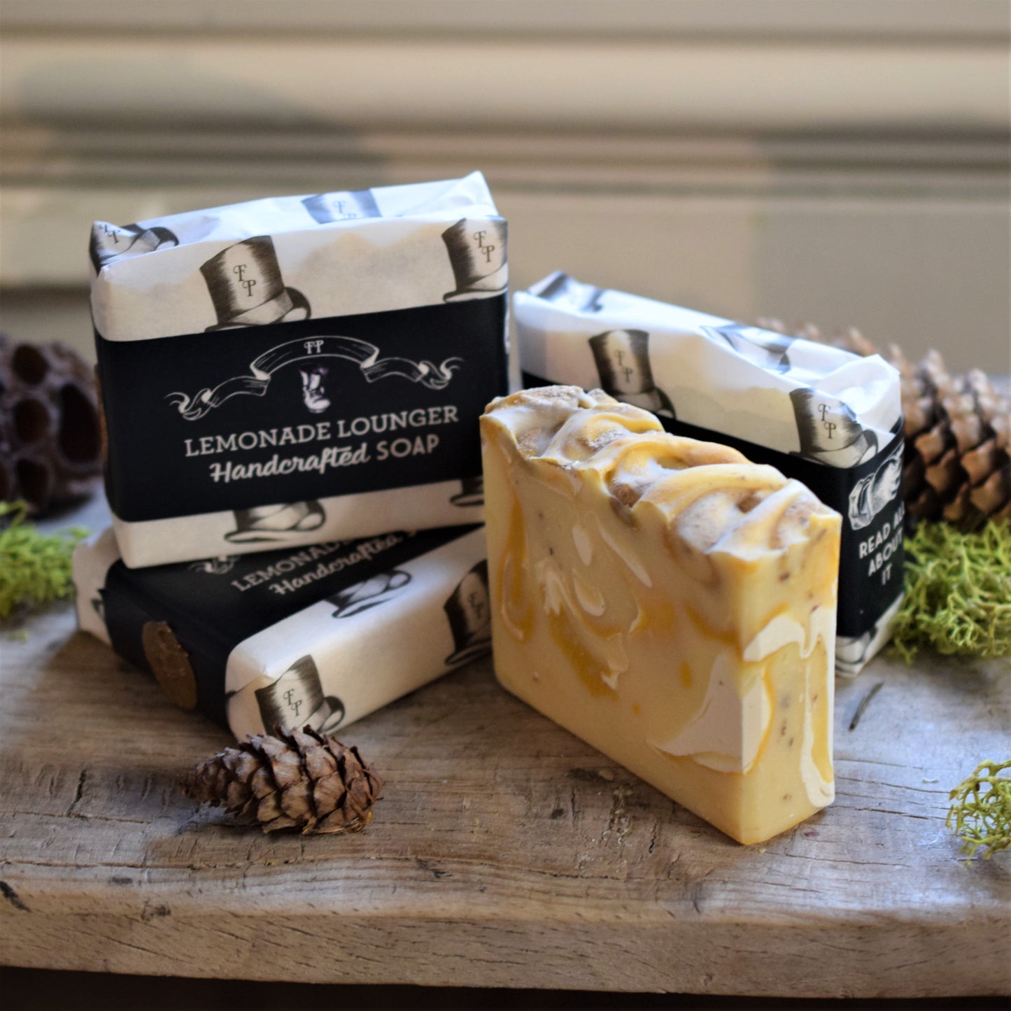 Handcrafted soap bars with packaging on a wooden surface