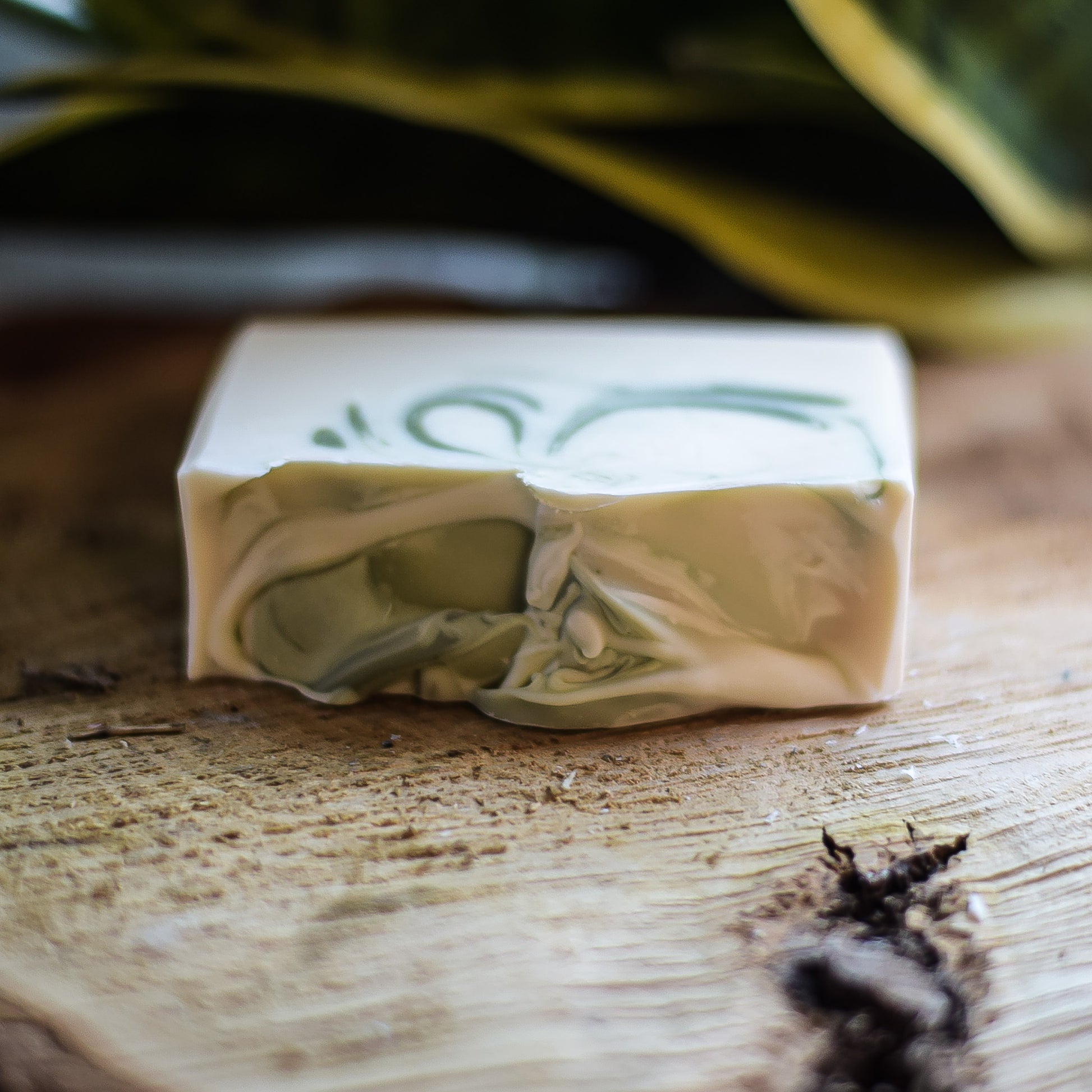 Bar of soap on a wooden surface with a blurred natural background