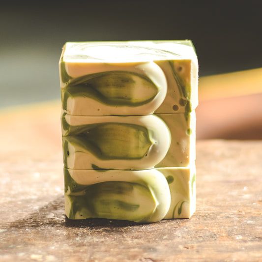 A stack of lime soaps on a wooden table with a blurred background
