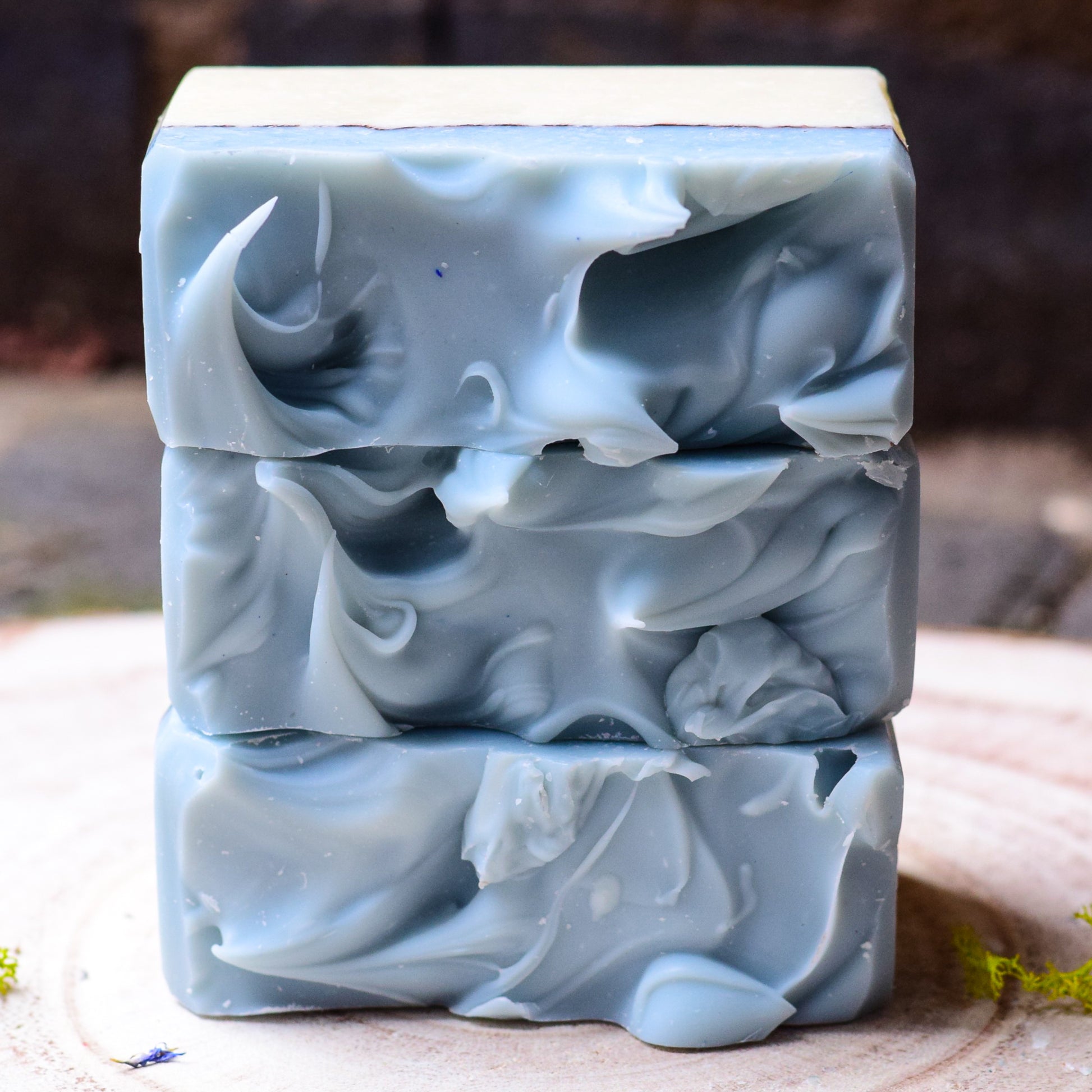 handmade bars of soap with a blue and white design on a wooden surface