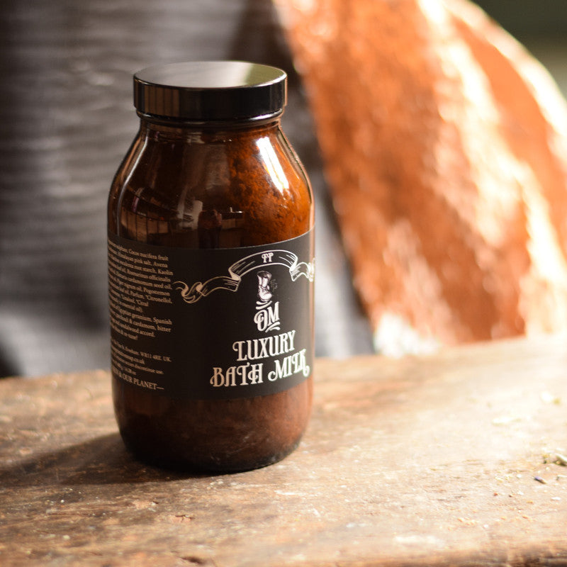 Brown jar of luxury bath mud on a wooden surface with a blurred background