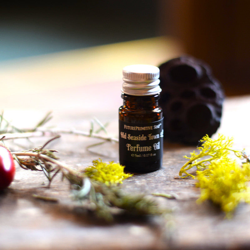 Perfume oil bottle on a wooden surface with natural elements