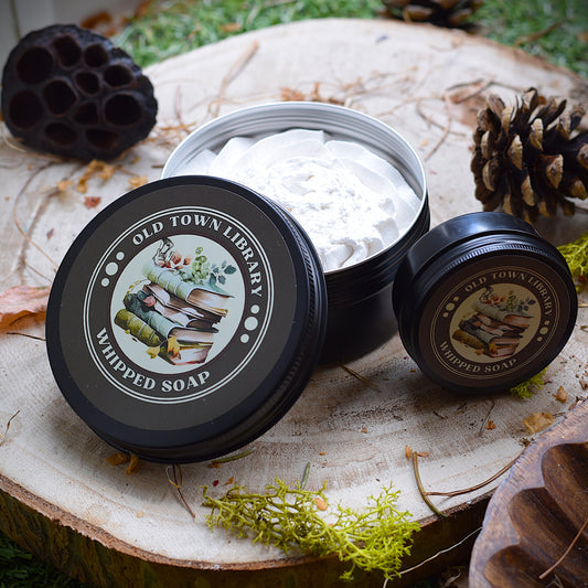 Open container of Old Town Library whipped soap on a natural wooden surface with decorative elements.