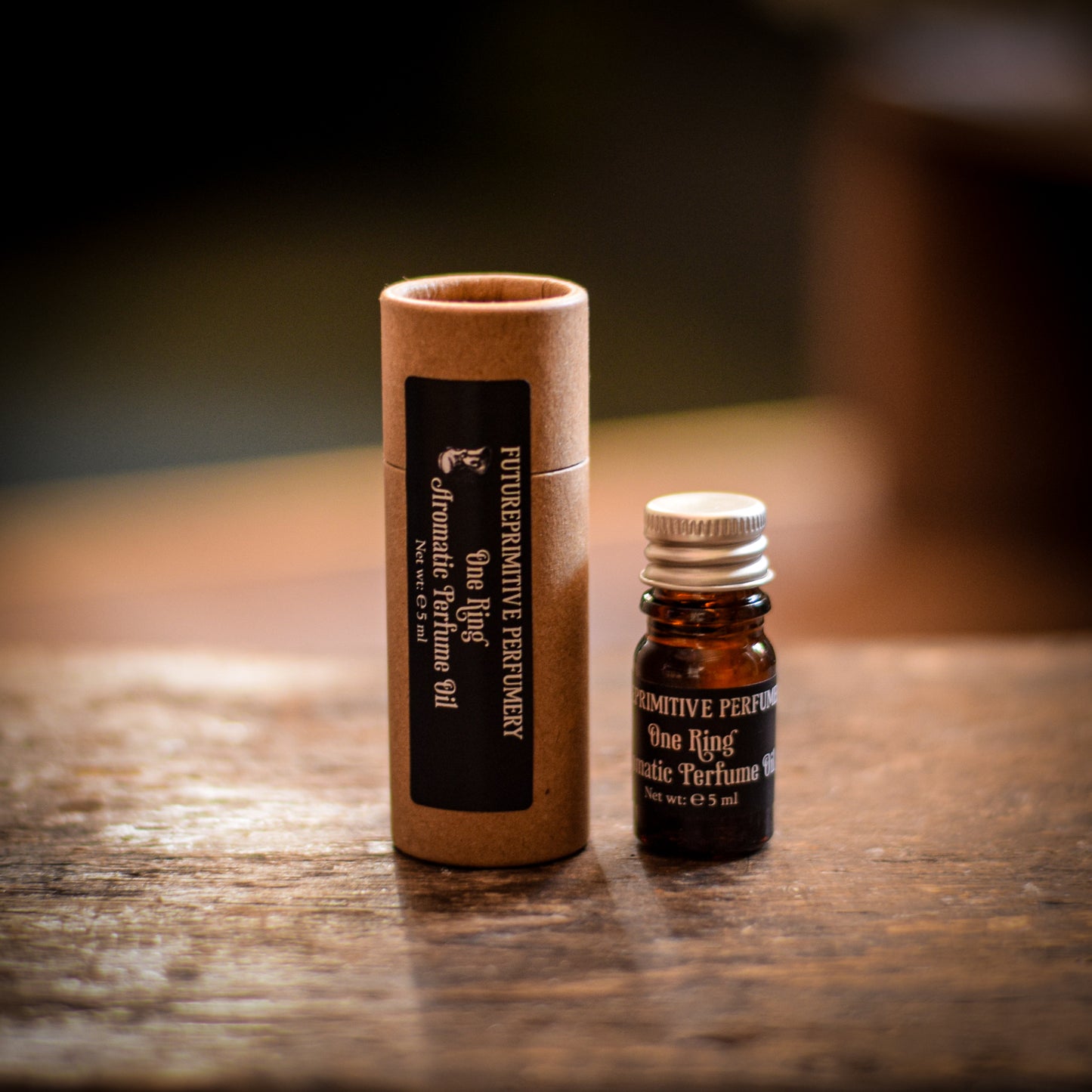 Primitive Perfume bottle and cardboard tube on a wooden surface
