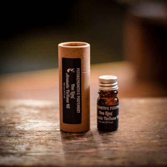Primitive Perfume bottle and cardboard tube on a wooden surface
