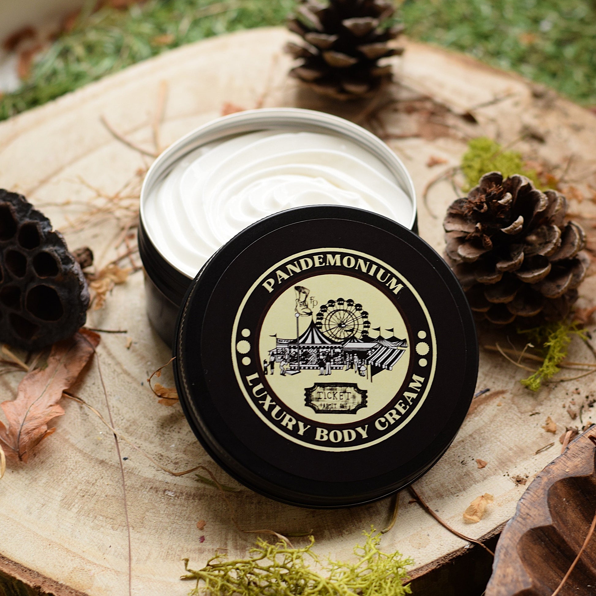 Pandemonium Luxury Body Cream jar on a natural wooden surface with pine cones and leaves.