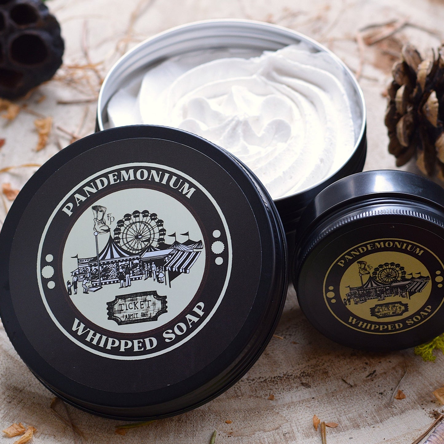 Pandemonium whipped soap sat in natural light surrounded by pine cones