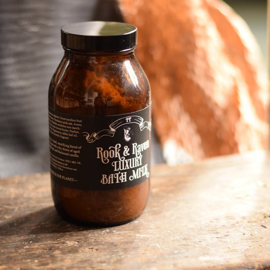 Brown apothercary bottle with black label on a wooden surface, blurred orange object in the background