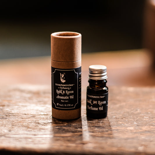 Perfume oil bottle and cardboard tube on a wooden surface