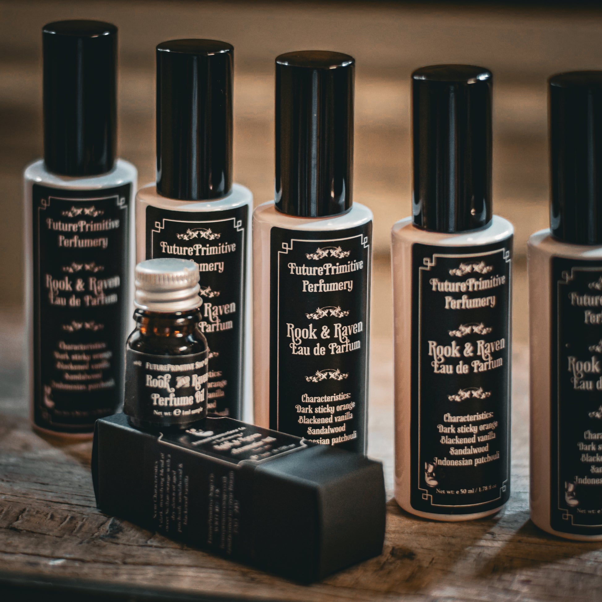 Collection of 'Future Primitive Perfumery' perfume bottles on a wooden surface.