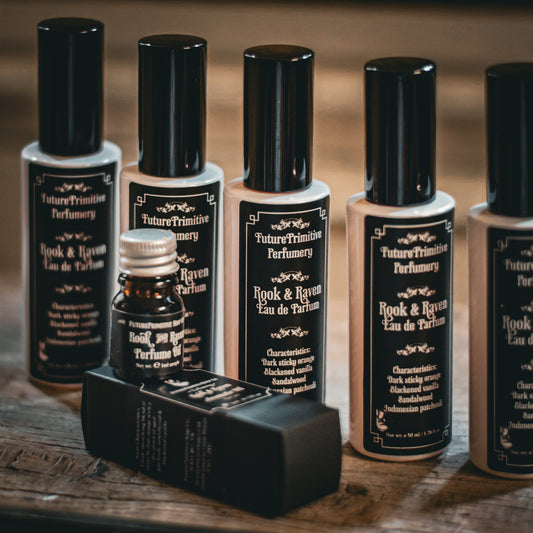 Collection of 'Future Primitive Perfumery' perfume bottles on a wooden surface.