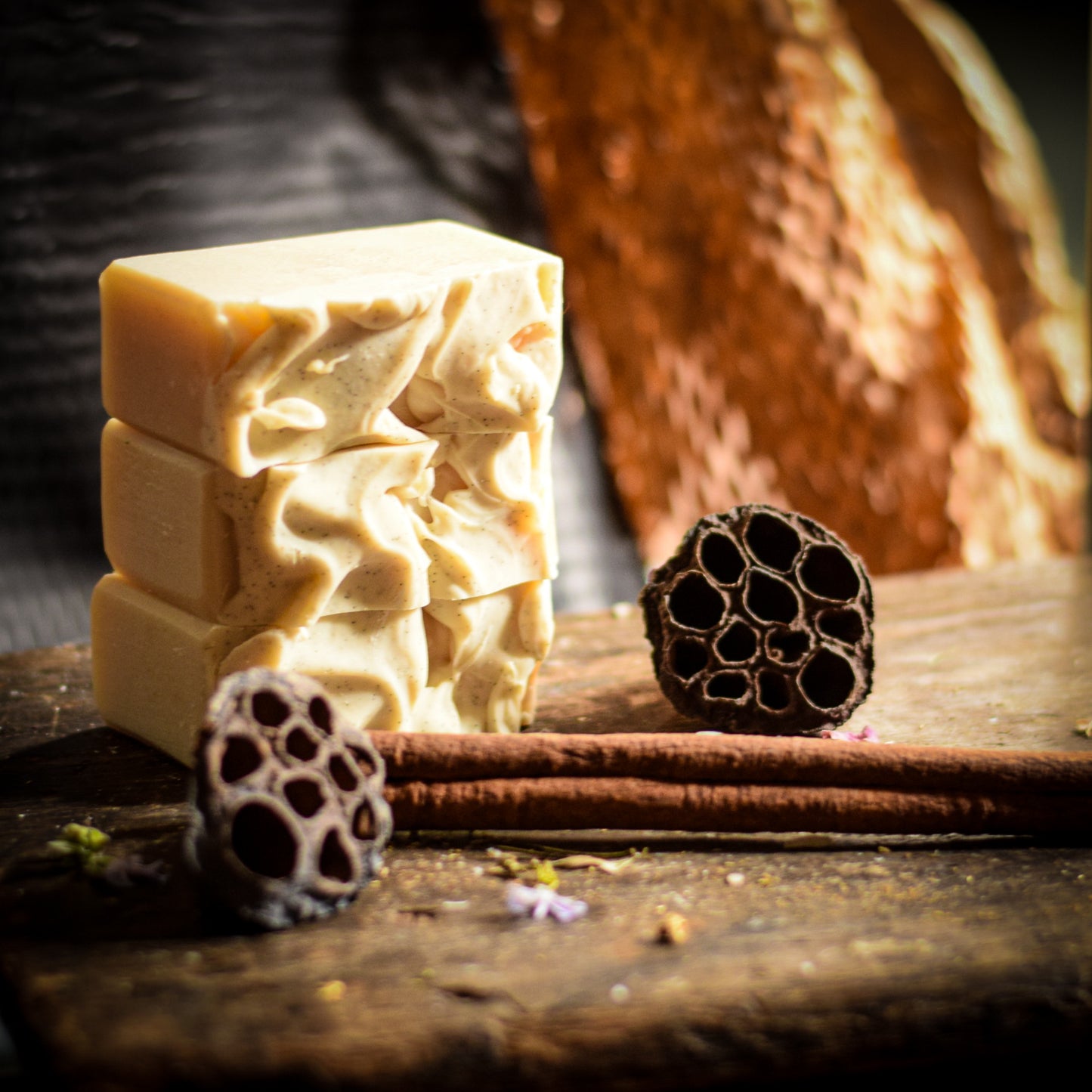 Three stacked soap bars with lotus flower bulbs on a wooden surface