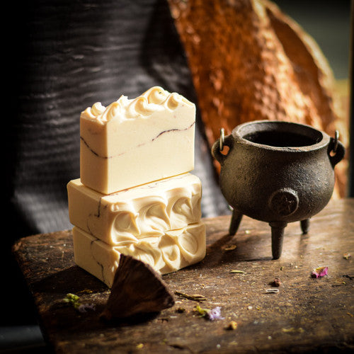 White Witch handmade soap stack with a black cauldron on a wooden table