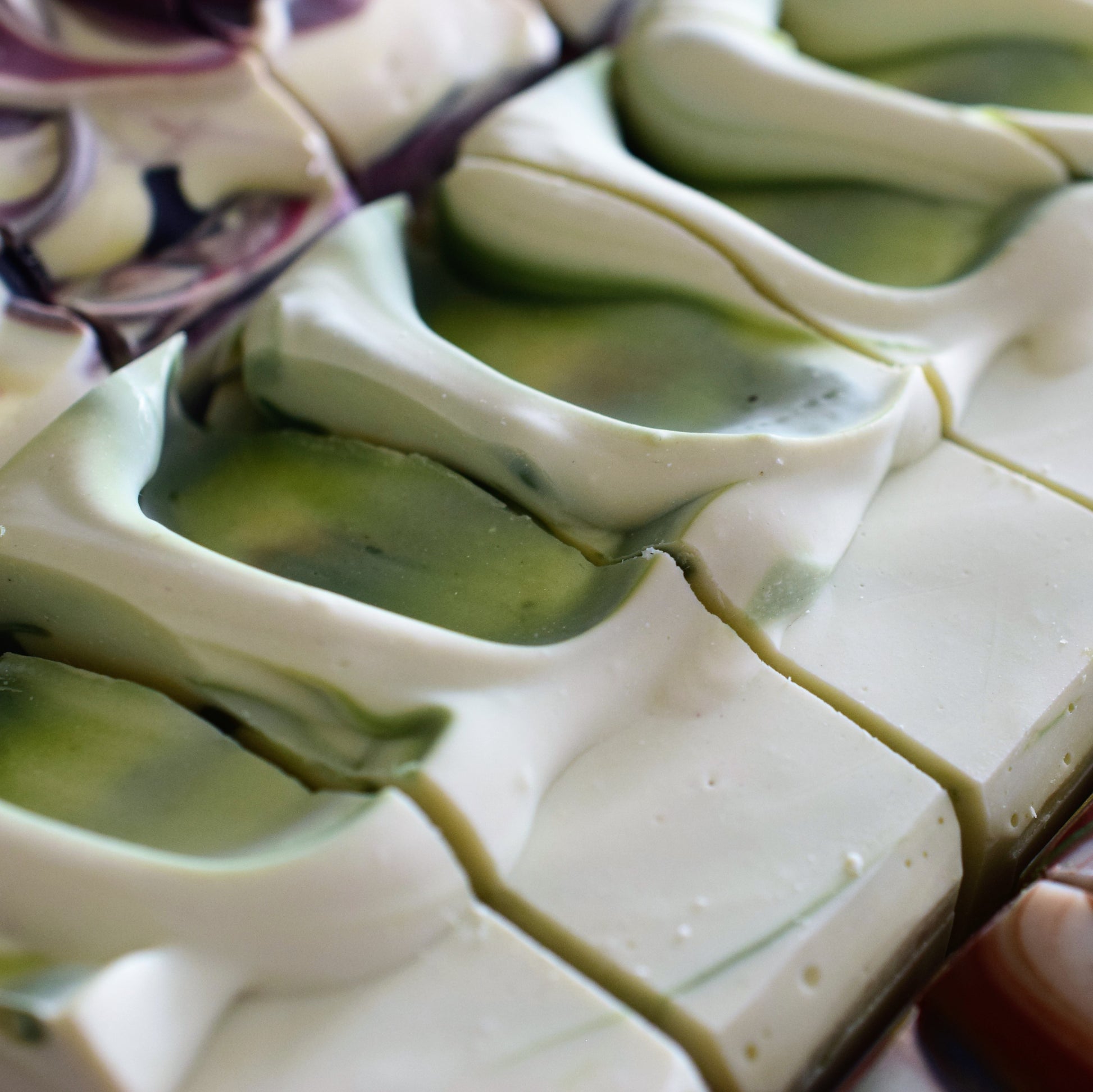 Close-up of a soap mold with green and white soap bars.