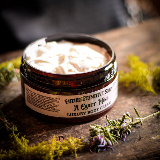 Jar of 'A Quiet Mind' luxury body cream on a wooden surface with herbs.