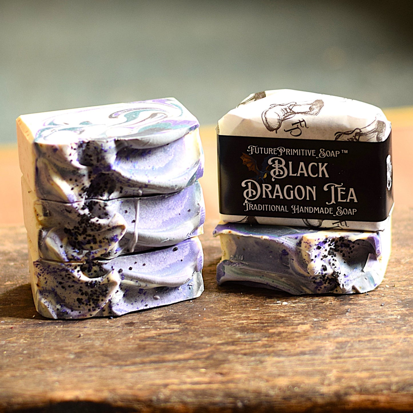 Two bars of soap with decorative packaging on a wooden surface