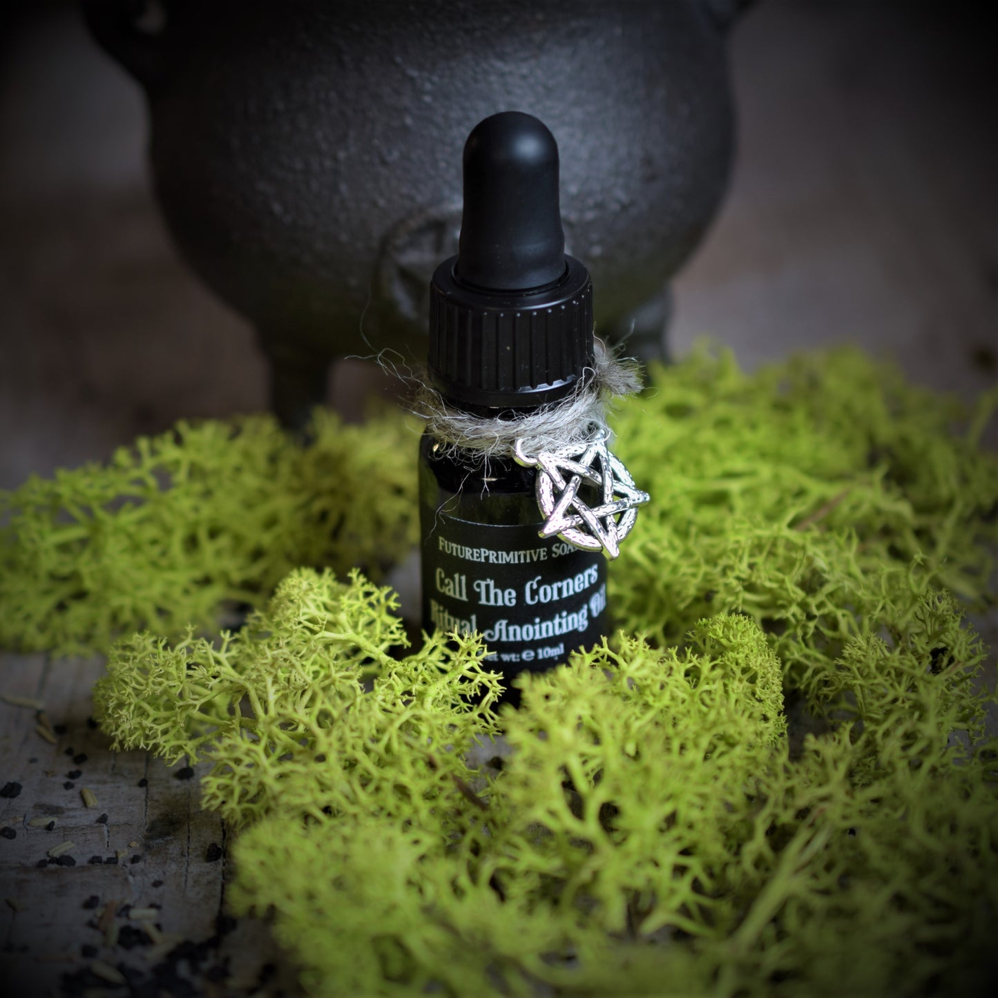 Black bottle with dropper on green moss with a blurred background