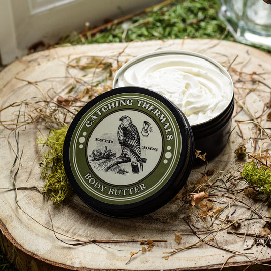 Body butter container with green label on a wooden surface with natural elements