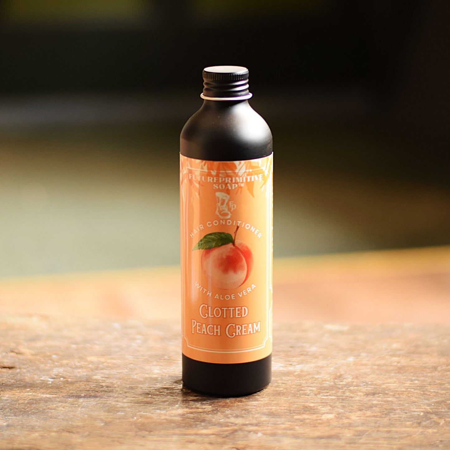 Bottle of Clotted Peach Cream conditioner on a wooden surface with a blurred background