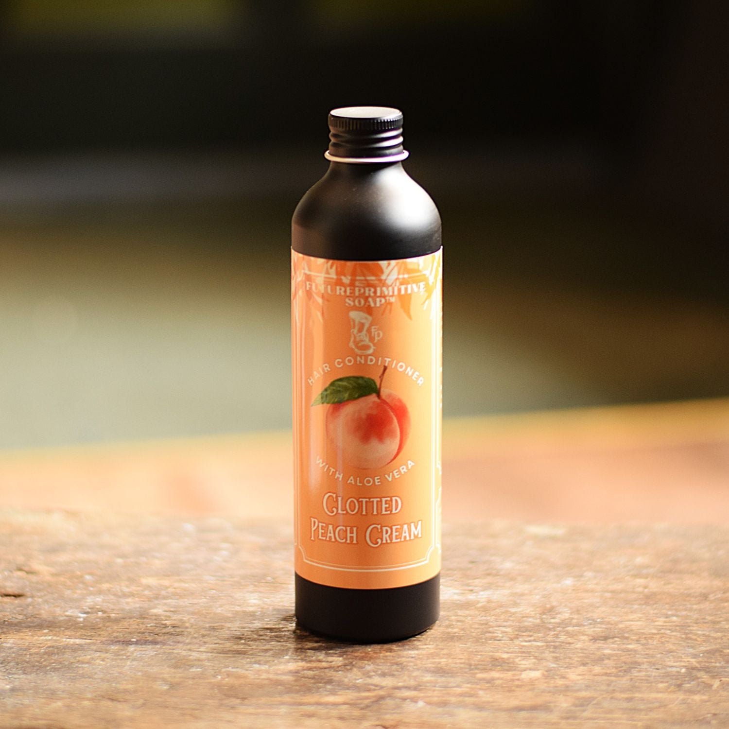 Bottle of Clotted Peach Cream conditioner on a wooden surface with a blurred background