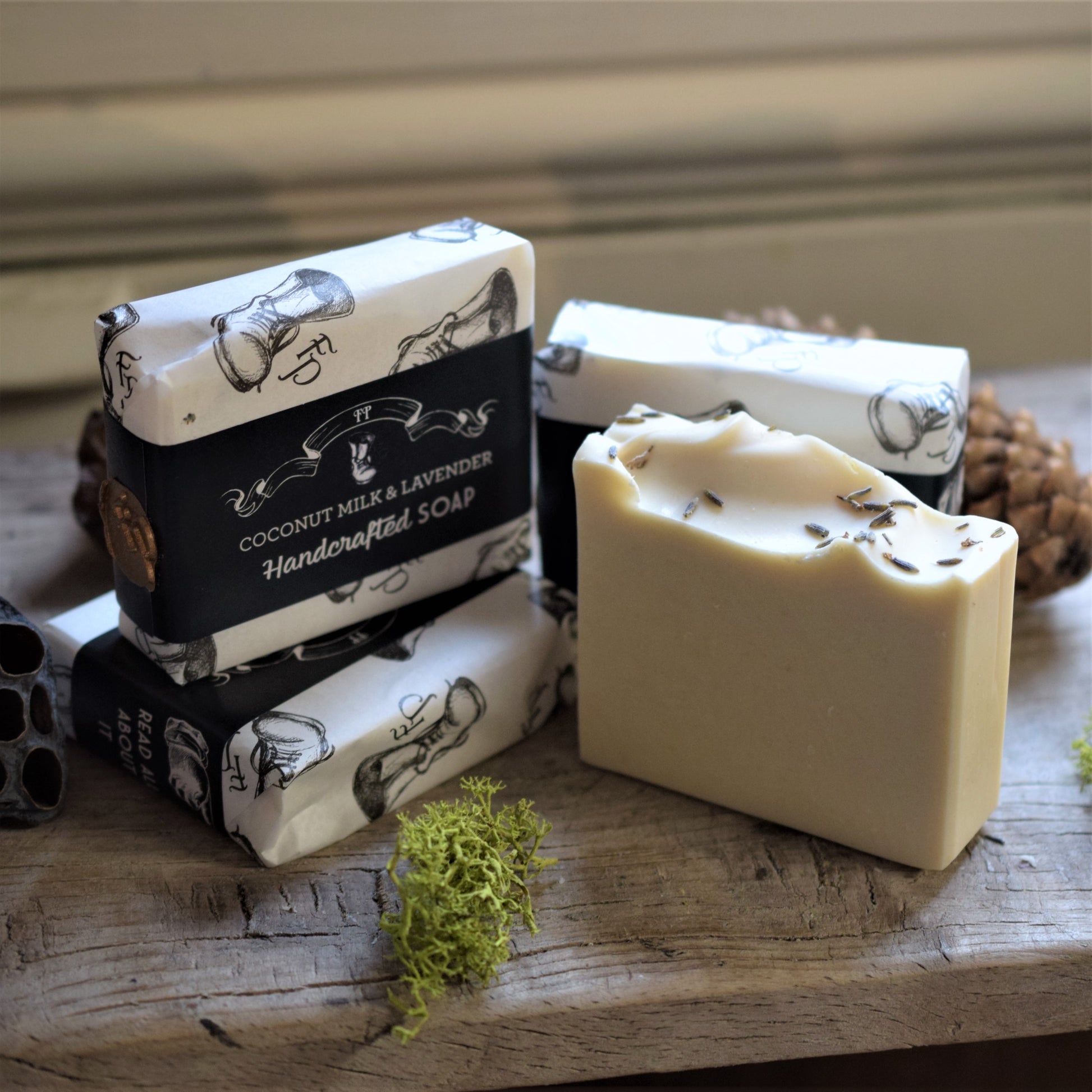 Handcrafted soap bars with pretty packaging on a wooden surface