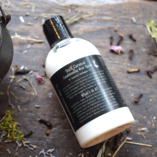 Bottle of 'Black Carnival' hair product on a wooden surface with natural elements.