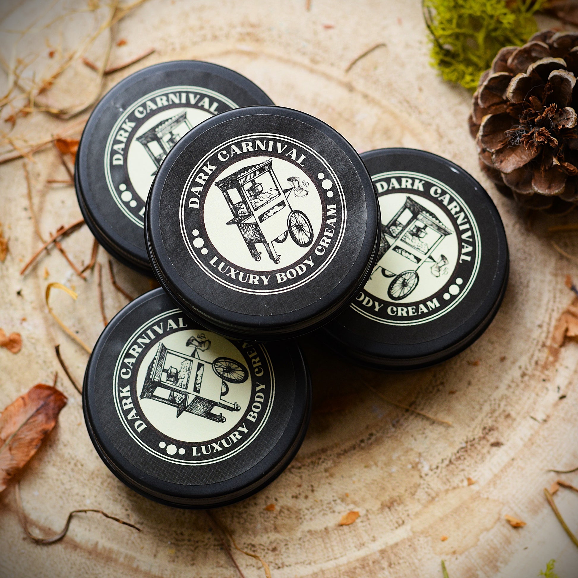 Dark Carnival mini body creams on a natural background with pine cones and moss