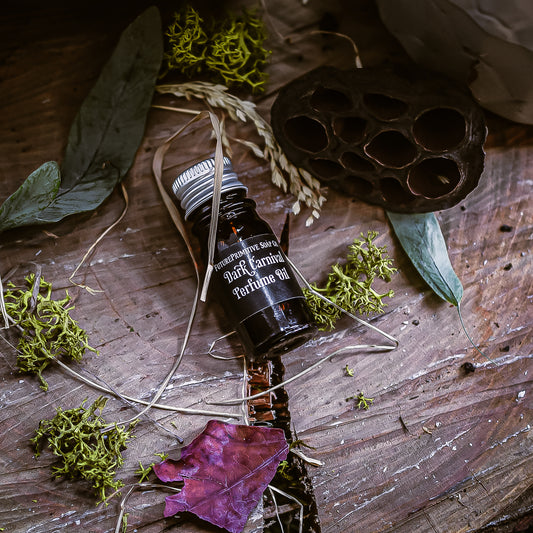 Bottle of Dark Cornich perfume oil on a wooden surface with leaves and natural elements