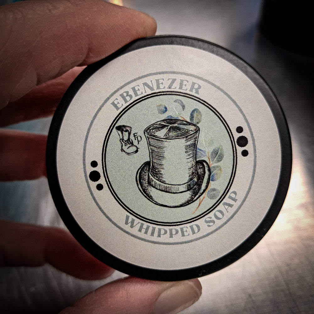 Round container labeled 'Ebenezer Whipped Soap' held by a hand.