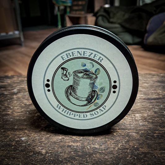 mini Ebenezer whipped soap sat upright on a dark oak table.