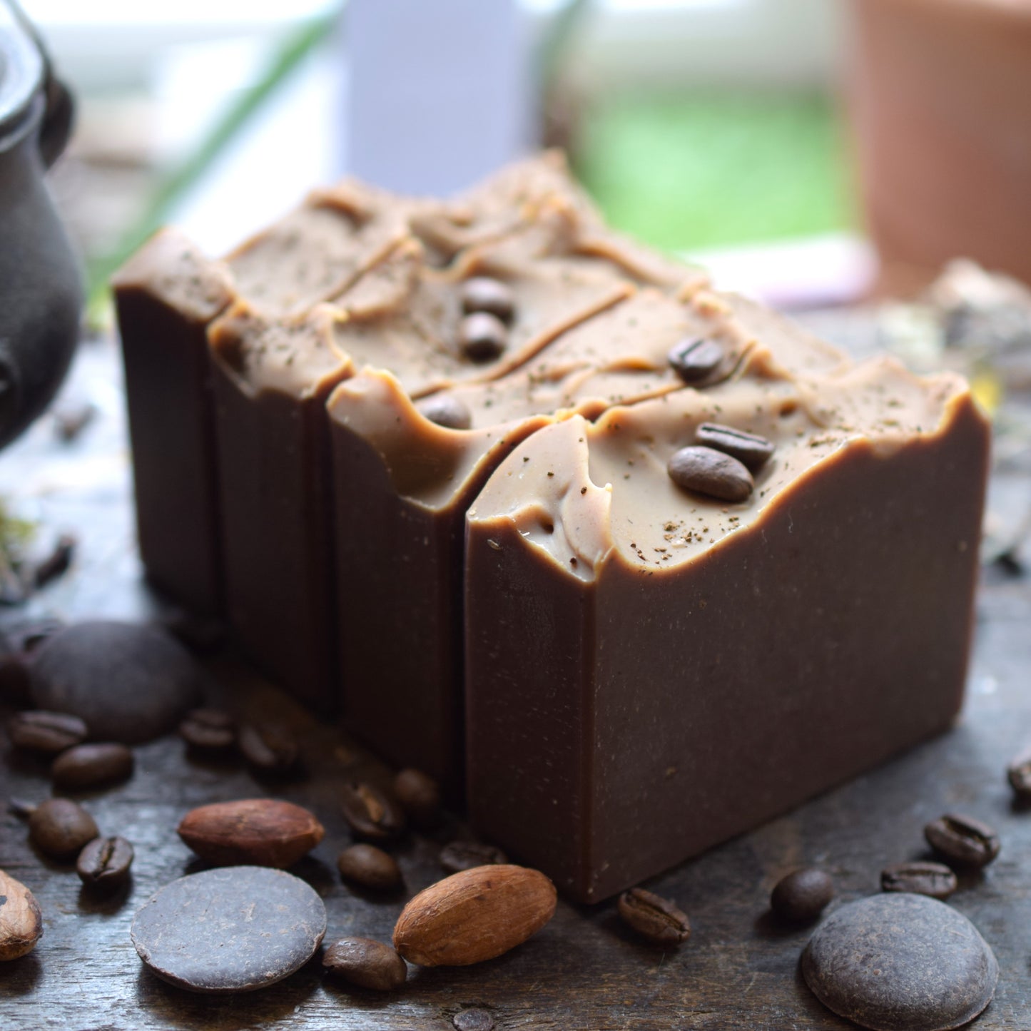 blocks of coffee-flavored soap with coffee beans on a dark surface