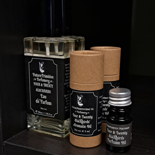 Collection of perfume bottles and containers with black labels on a dark background