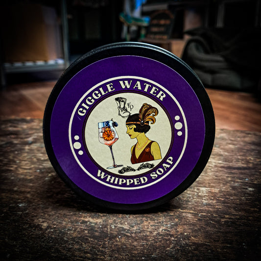 Gigglw Water Whipped soap on a dark wood table