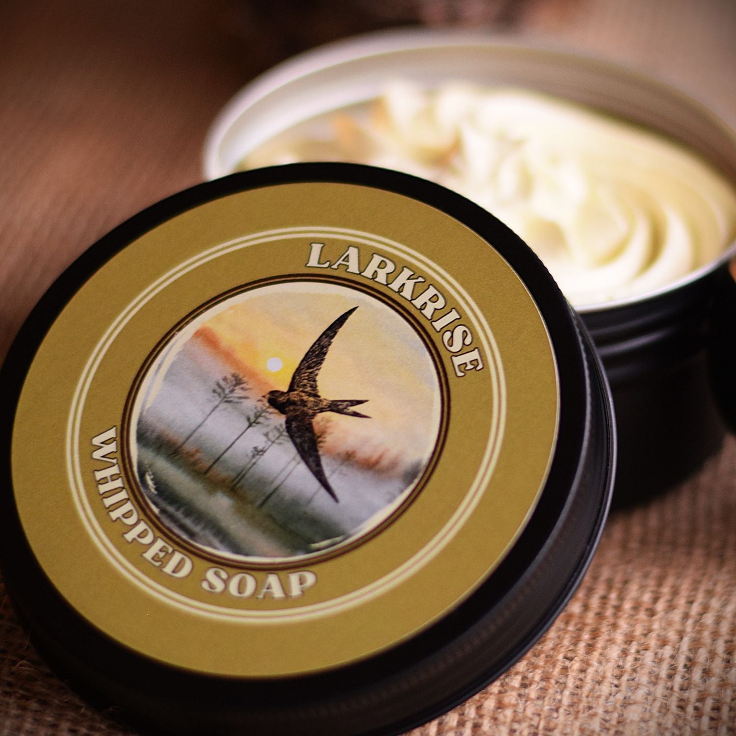 Larkrise whipped soap in a black container with a decorative label featuring a bird.