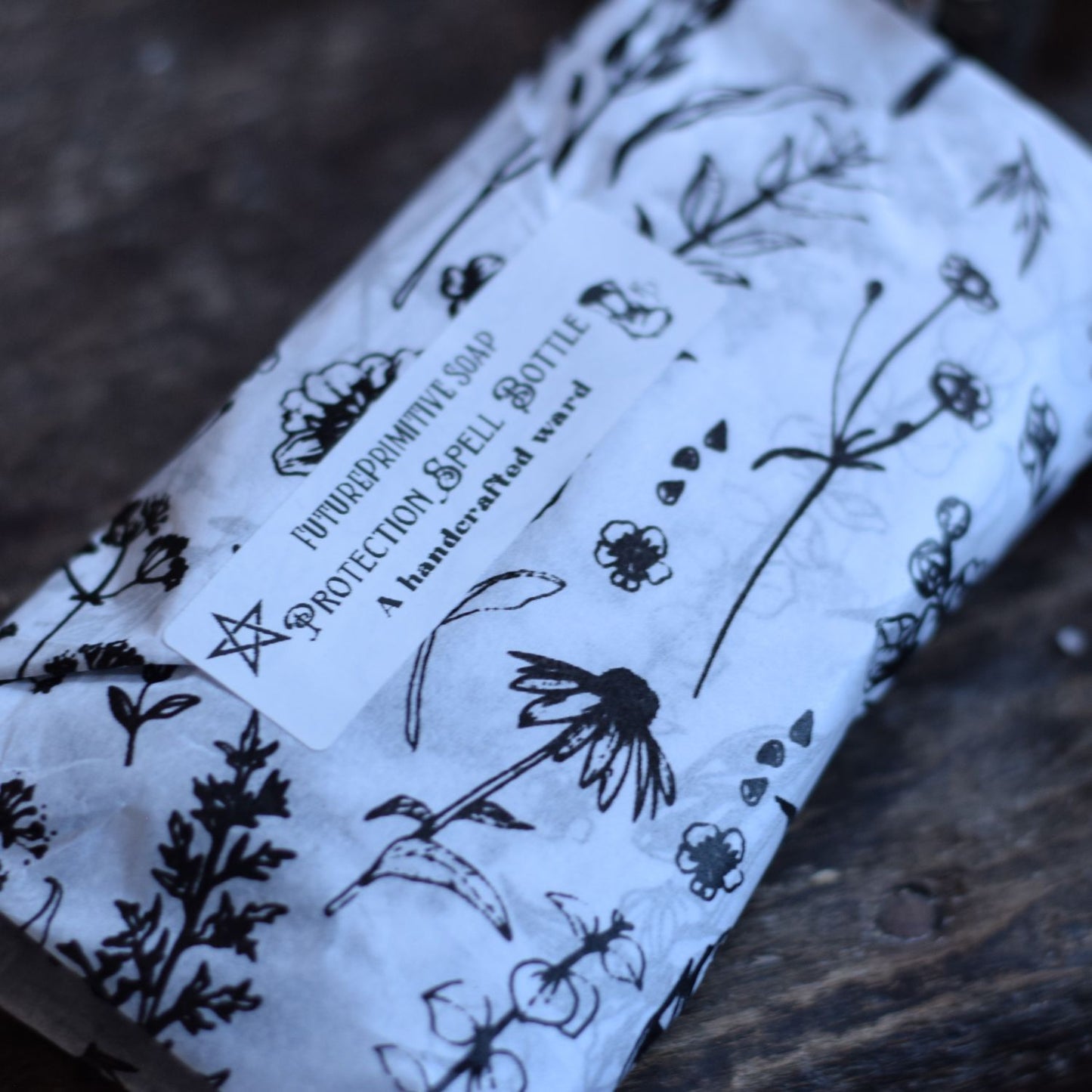 spell bottle packaged in black and white botanical tissue