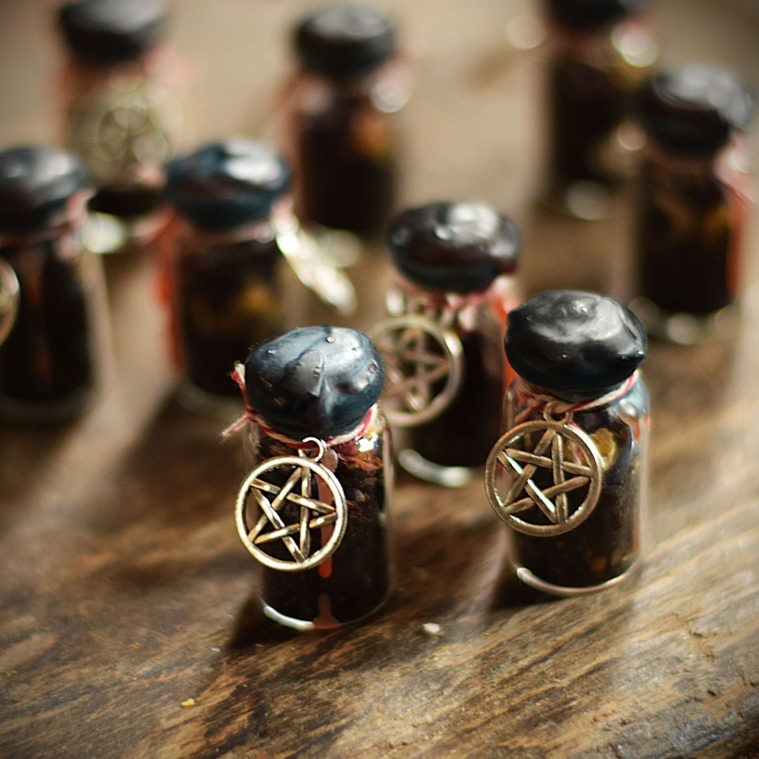 Small glass bottles with pentagram charms on a wooden surface