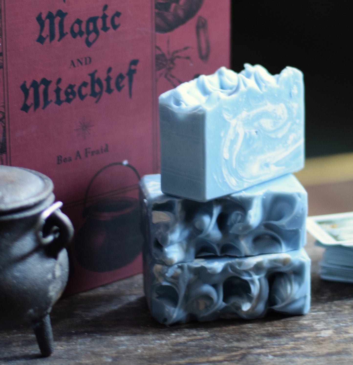 Stack of soap bars with a 'Magic and Mischief' book in the background