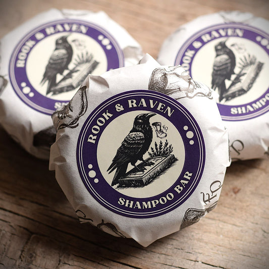 A round shampoo bar with the branding FuturePrimitive Rook and Raven sat on a wooden rustic table
